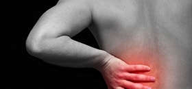 person holding lower back in pain