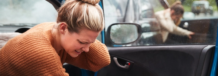 Woman holding her neck in pain after a car accident.