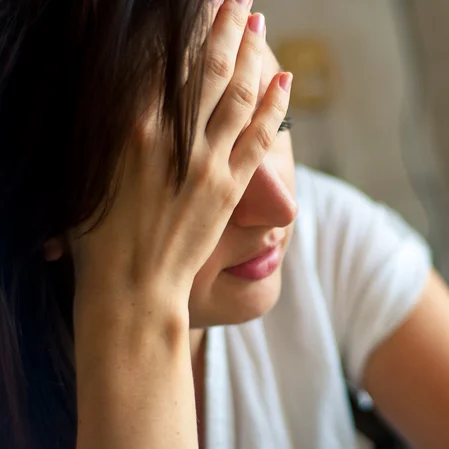 Woman holding her head in pain.